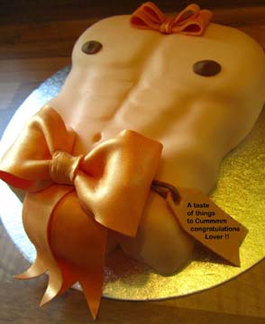 A cake shaped like a muscular male torso, covered in smooth fondant. It features orange bows on the chest and waist, and edible decorations resembling nipples. The cake sits on a round silver board.