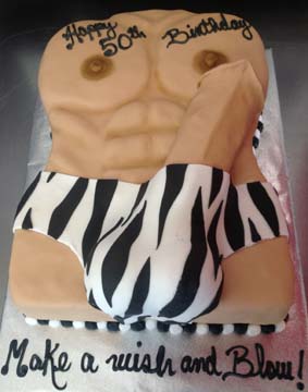 A cake shaped like a muscular torso, wearing zebra-striped underwear, with Happy 50th Birthday written on top. The cake has a humorous tone. The base reads Make a wish and blow!.