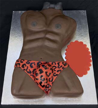 Cake shaped like a male torso wearing orange and black leopard-print underwear. The cake has sculpted muscles and is displayed on a silver board. Theres a blank red oval on the right side.